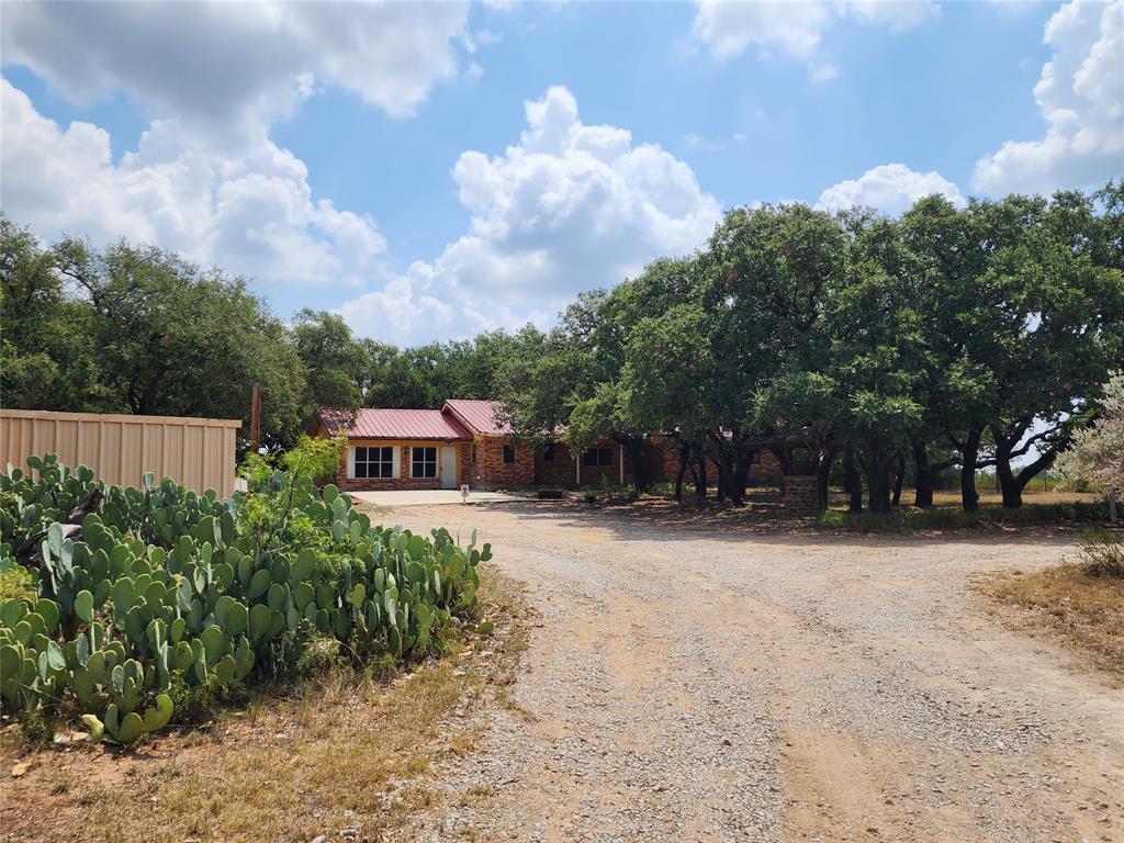 a front view of a house with a yard and trees