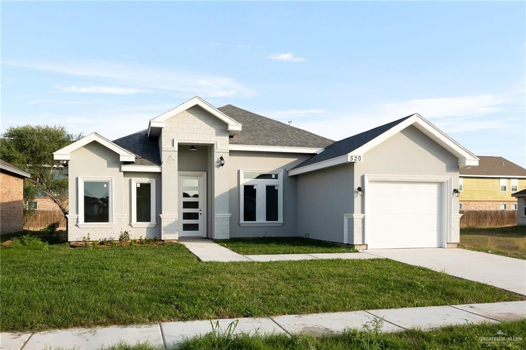 View of front of property with a front yard and a garage