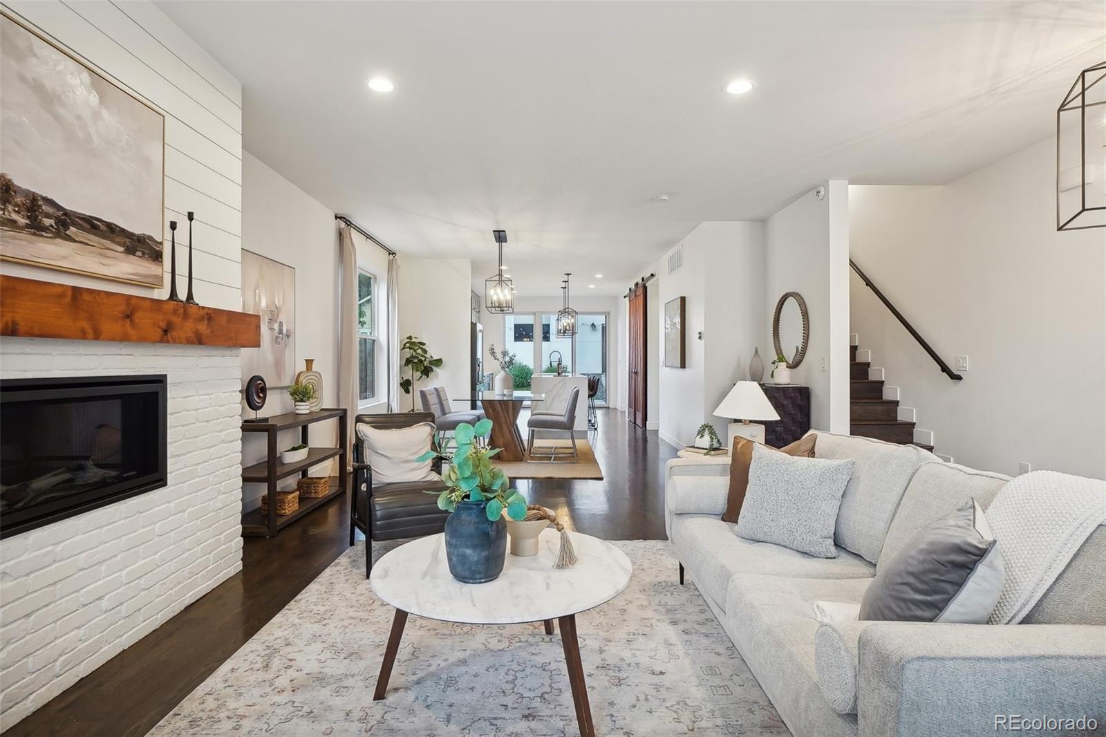 a living room with furniture kitchen view and a fireplace