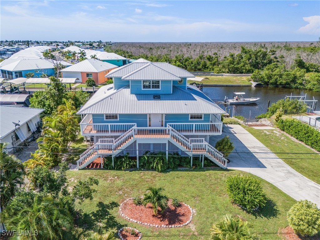 an aerial view of a house with a garden and lake view