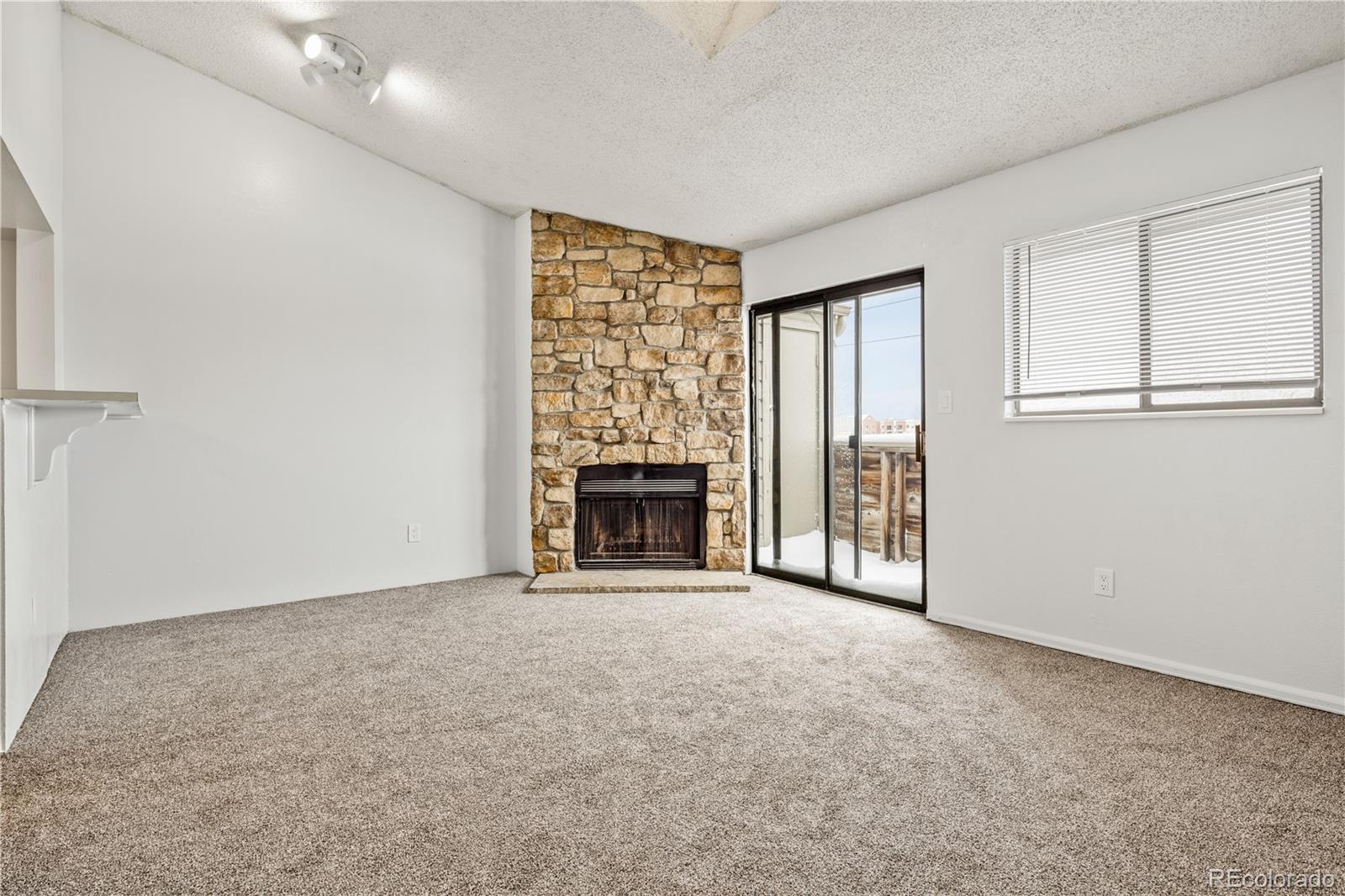 an empty room with windows and fireplace