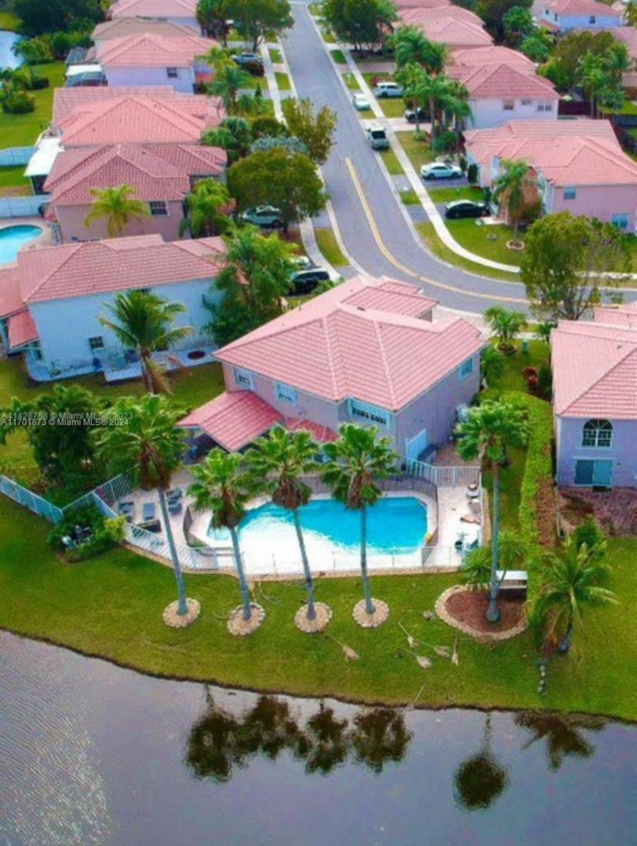 an aerial view of a house with a garden and lake view