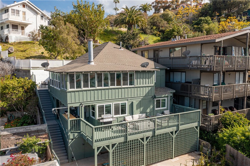 a view of a house with a deck and furniture