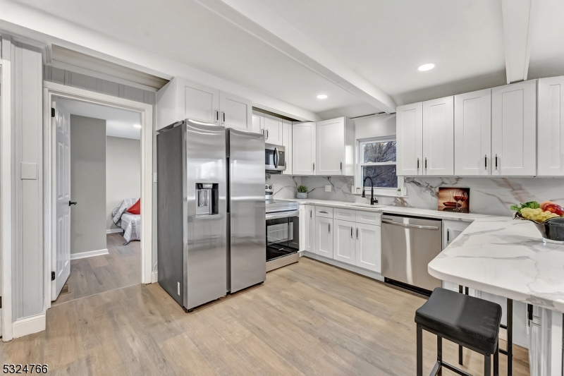 a kitchen with a refrigerator cabinets and wooden floor