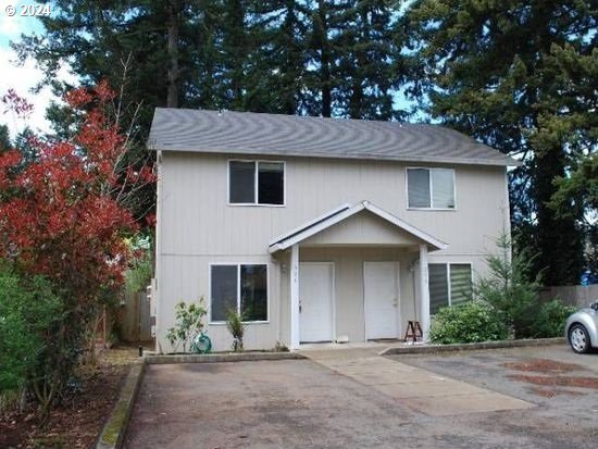 a front view of a house with a garden and yard