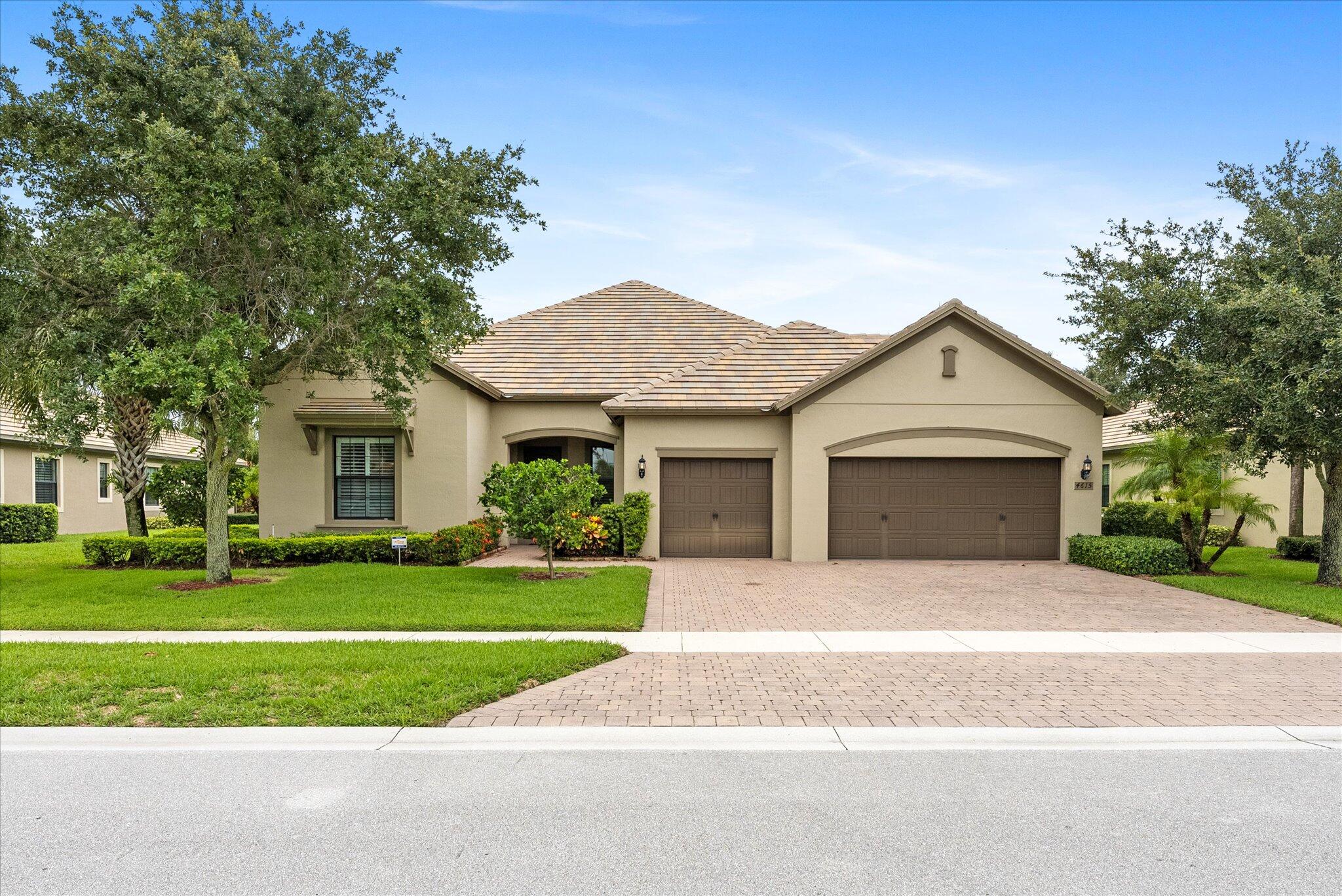 a front view of a house with a yard and trees