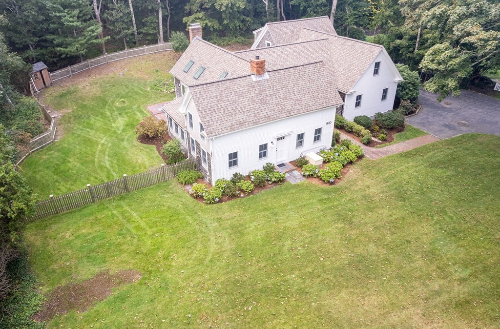 a aerial view of a house with table and chairs under an umbrella