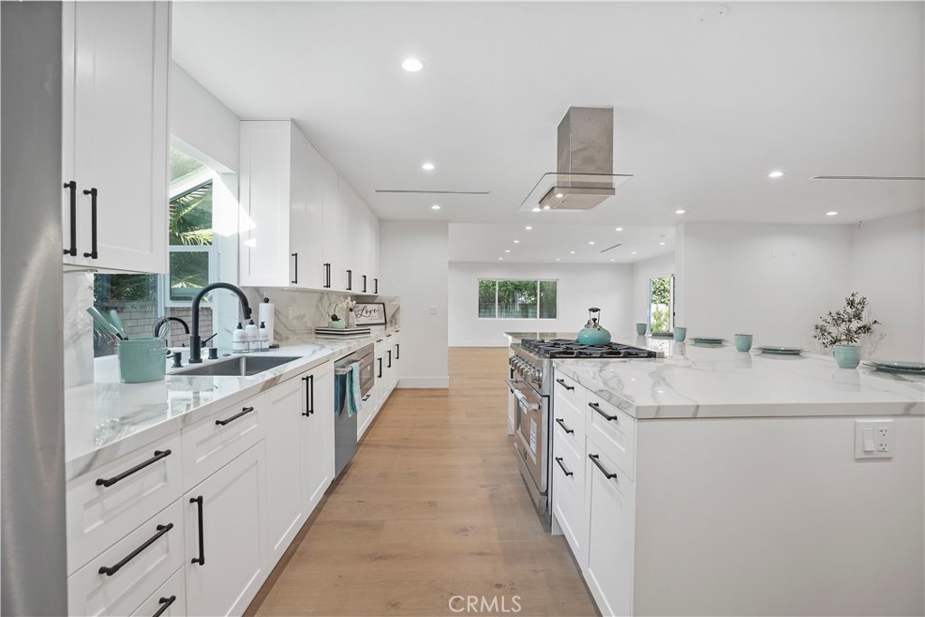 a kitchen with granite countertop a sink and white cabinets