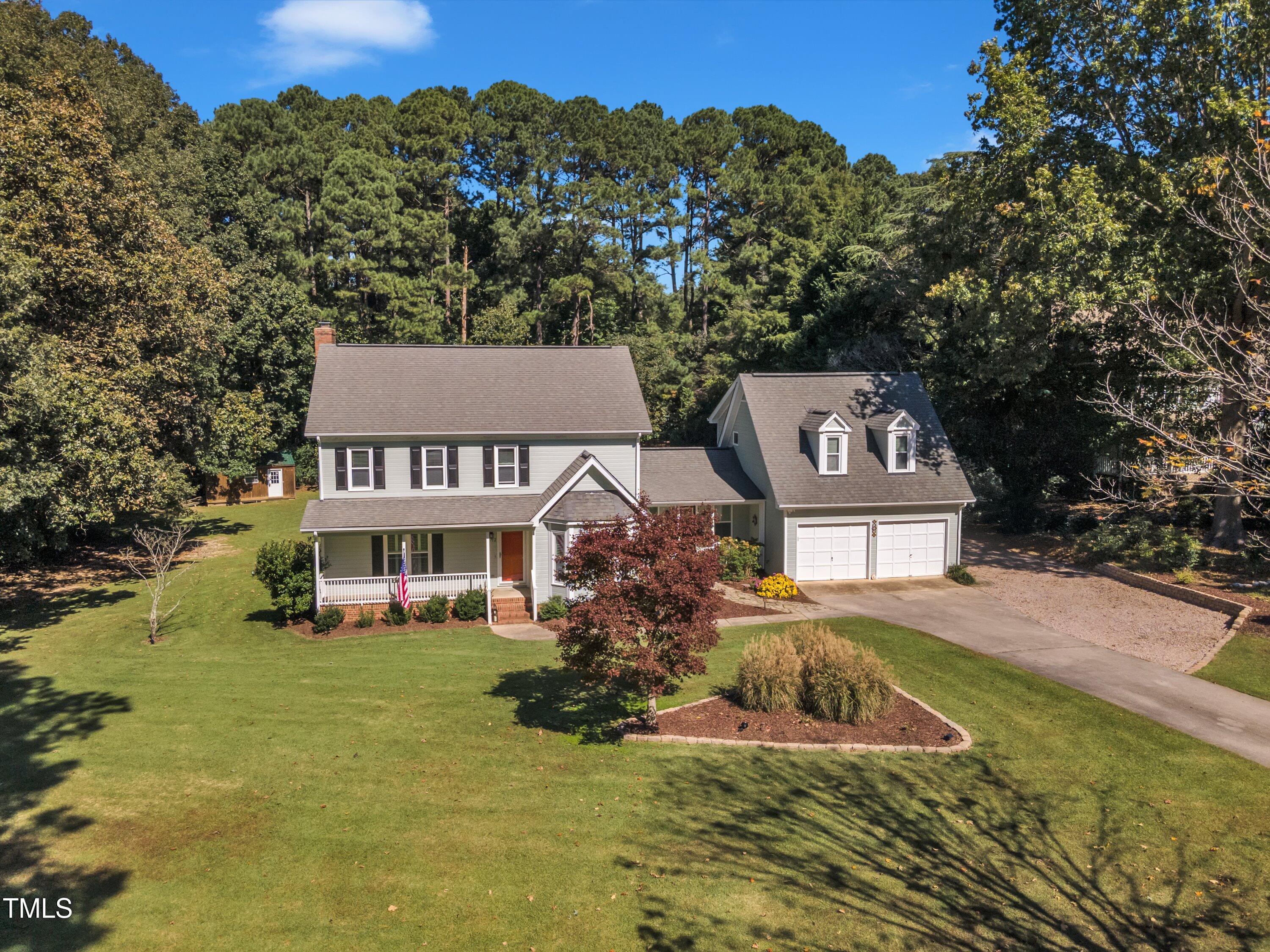 a view of a house with a big yard and large trees