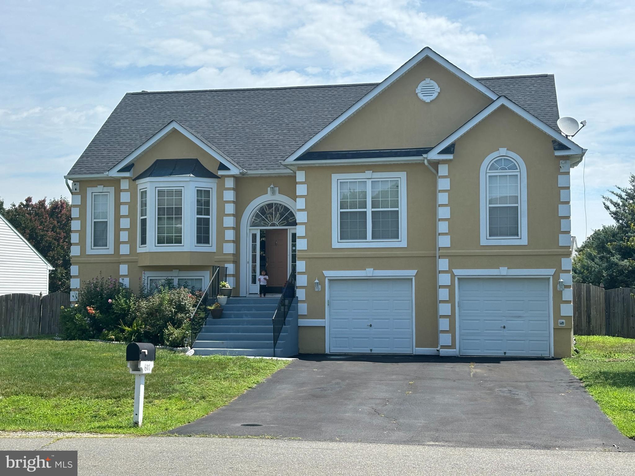 a front view of a house with a yard and a garden