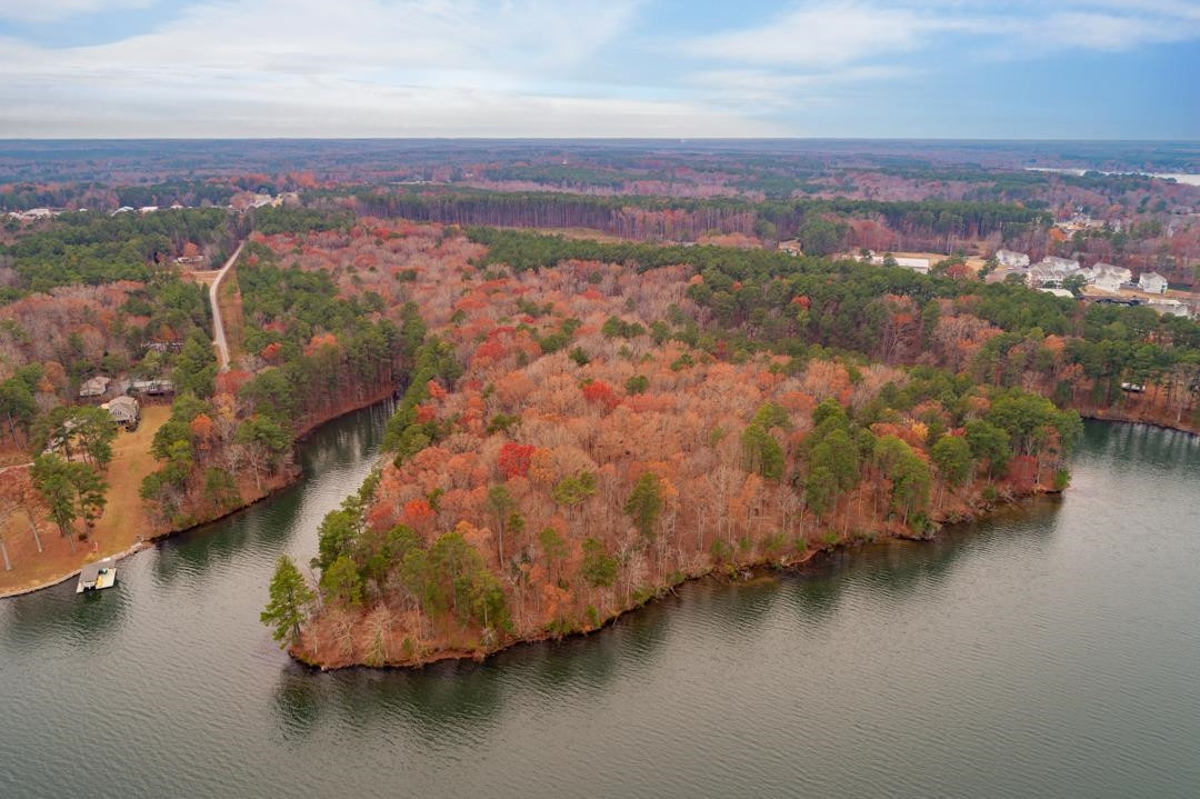 an aerial view of residential houses with outdoor space and lake view