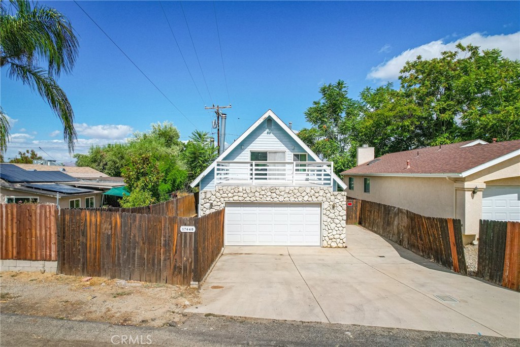 a view of a house with a yard and wooden fence