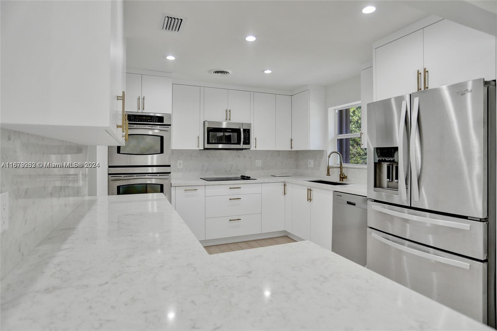 a kitchen with white cabinets and stainless steel appliances