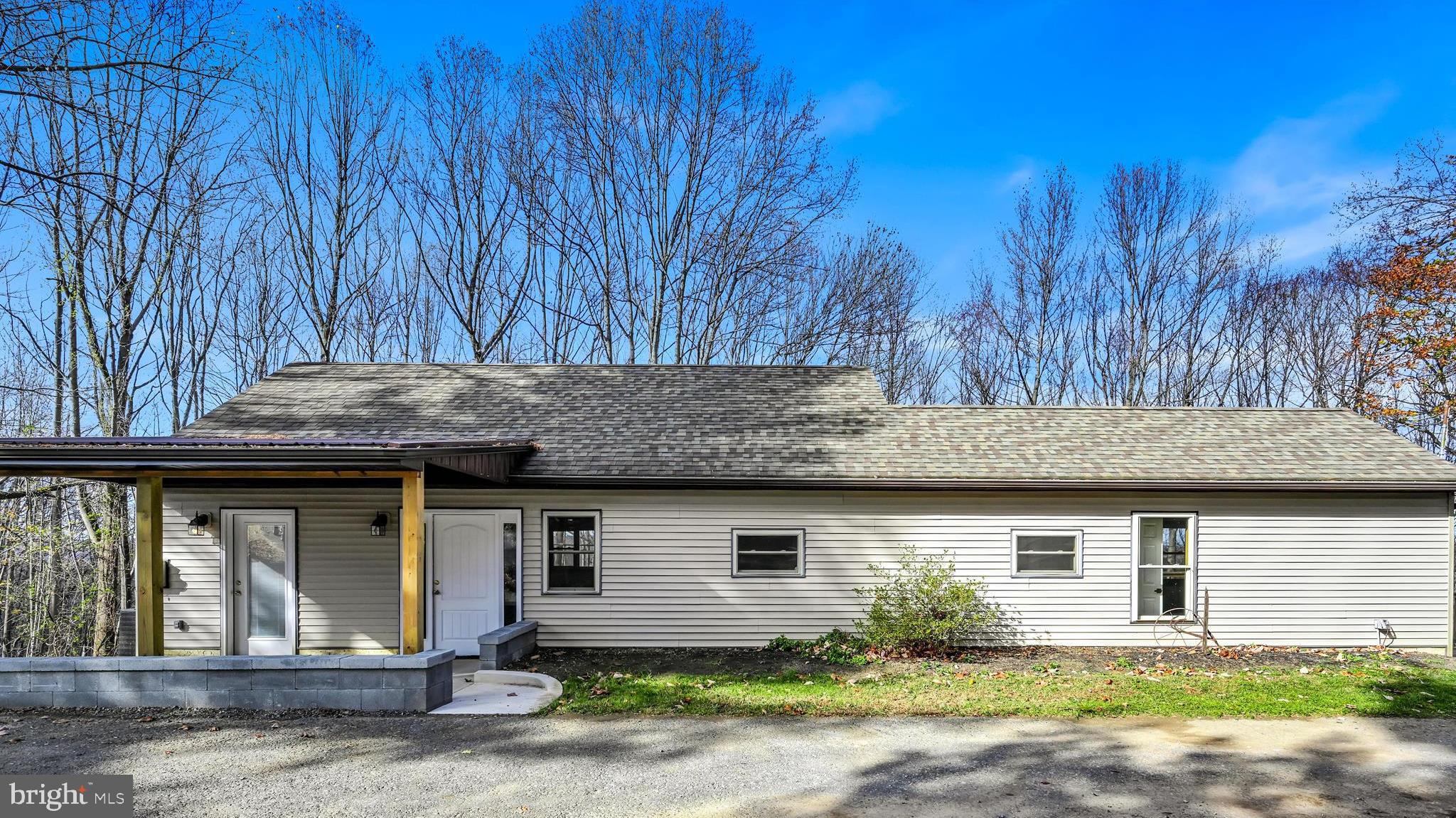 a front view of house with yard and trees around