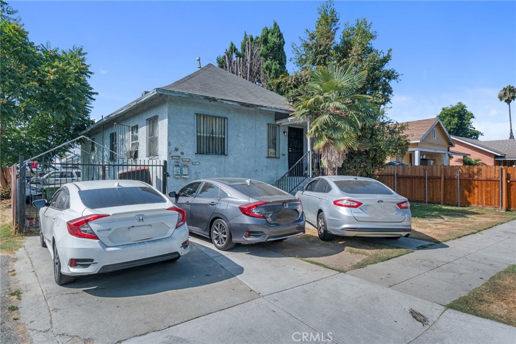 a front view of a house with cars parked on road