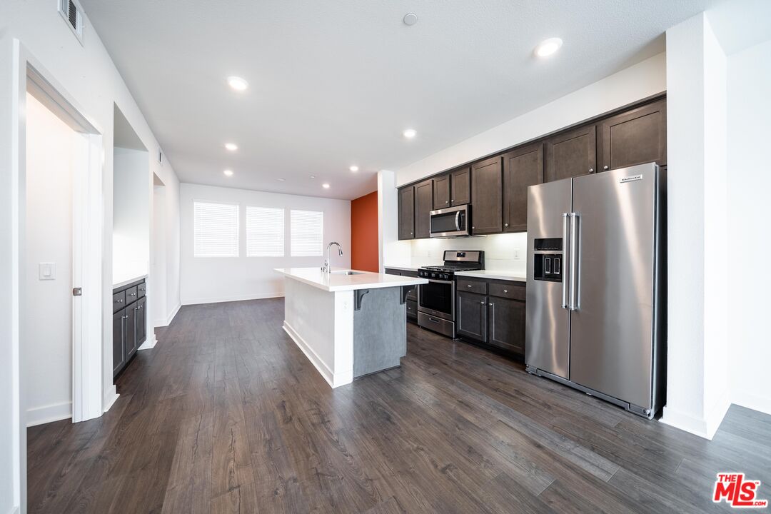 a kitchen with a refrigerator a sink and a stove top oven