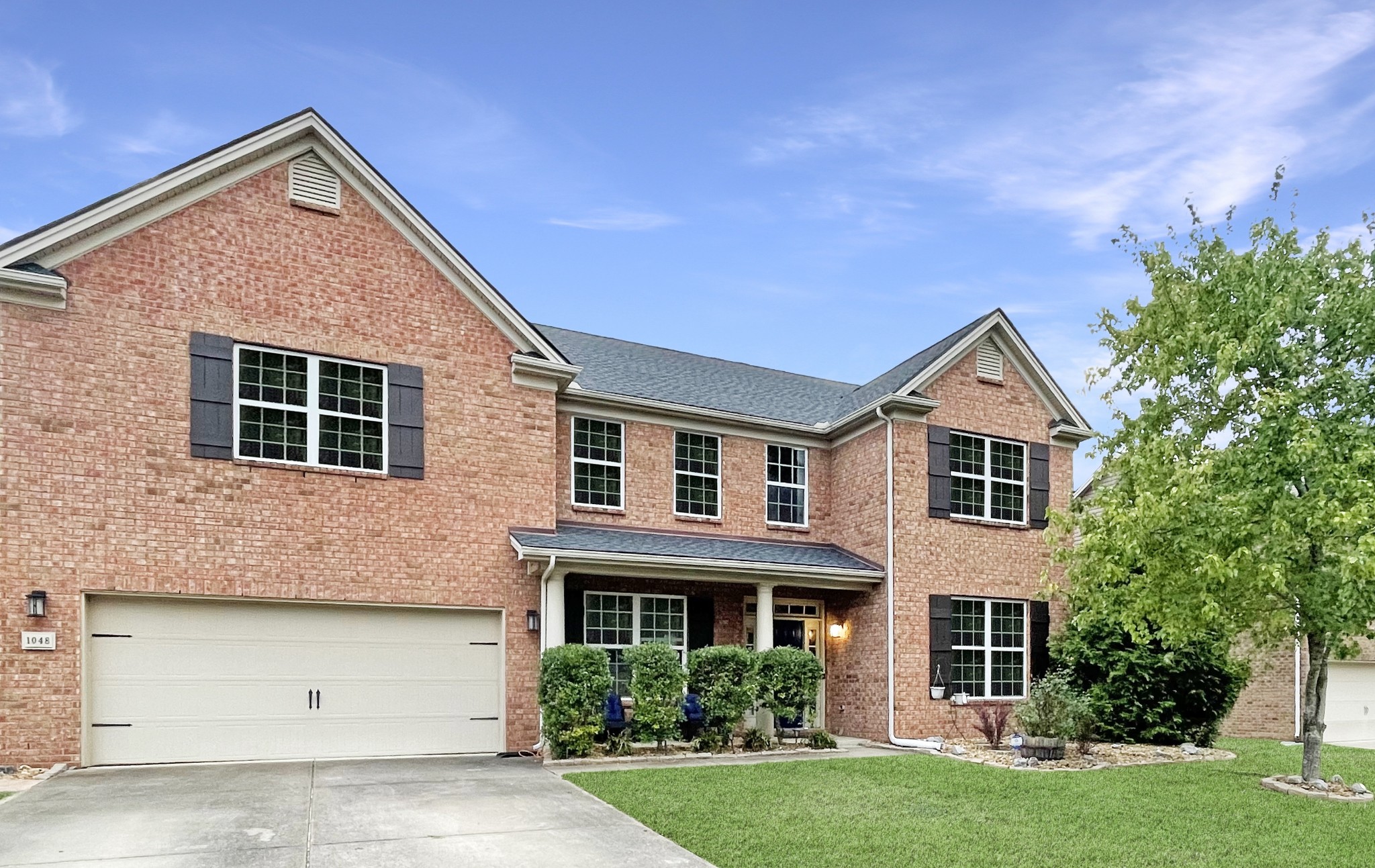 a front view of a house with a yard and garage