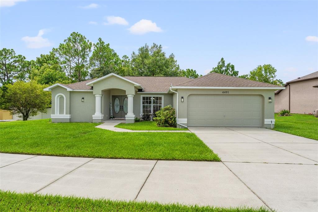 a front view of a house with a garden and yard