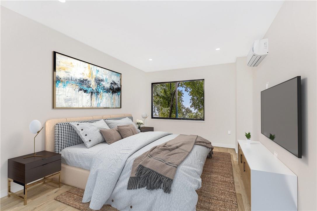 Bedroom featuring light wood-type flooring and a wall mounted air conditioner