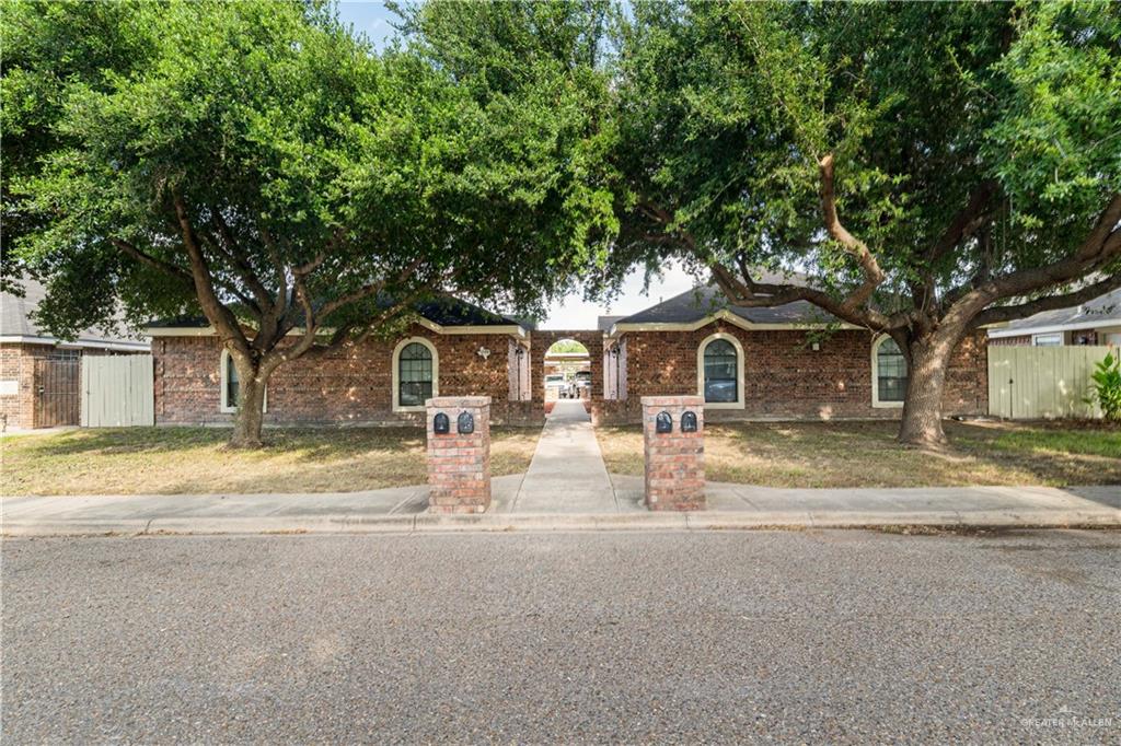 a front view of a house with yard and trees