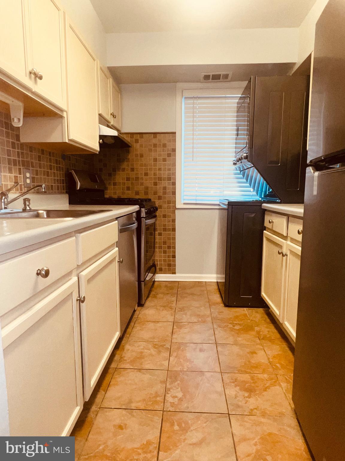 a kitchen with granite countertop a refrigerator and a stove