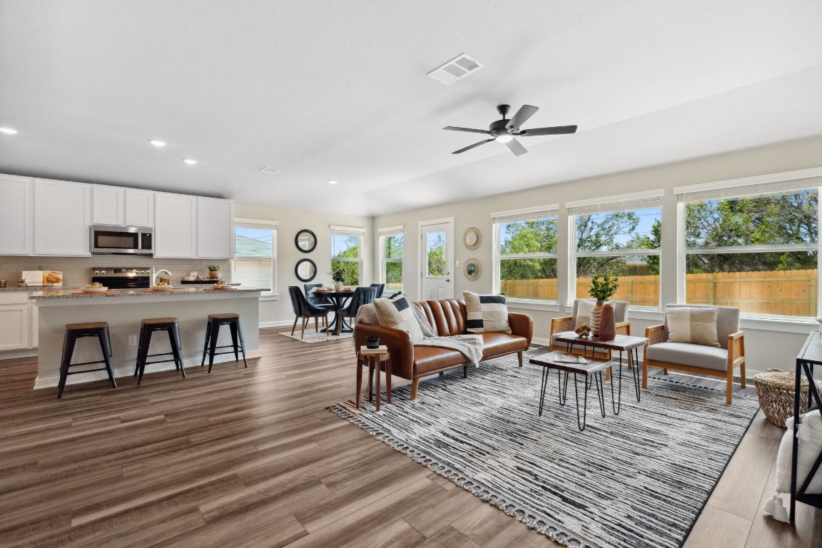 a living room with furniture dining table and a floor to ceiling window