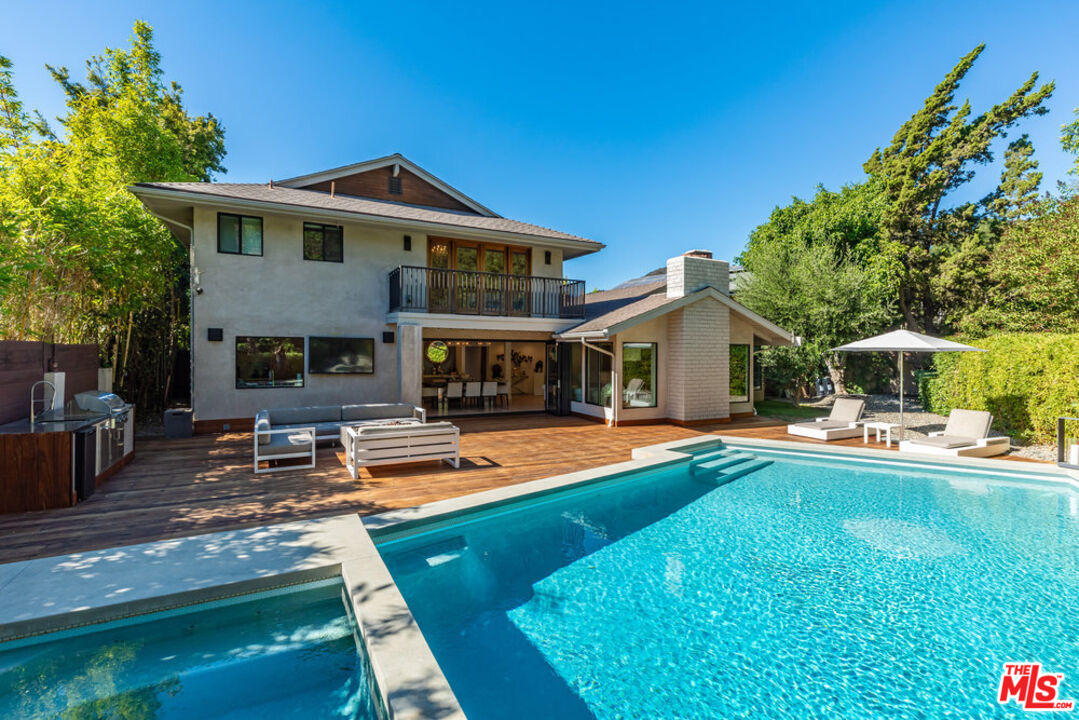 a view of a house with swimming pool and sitting area