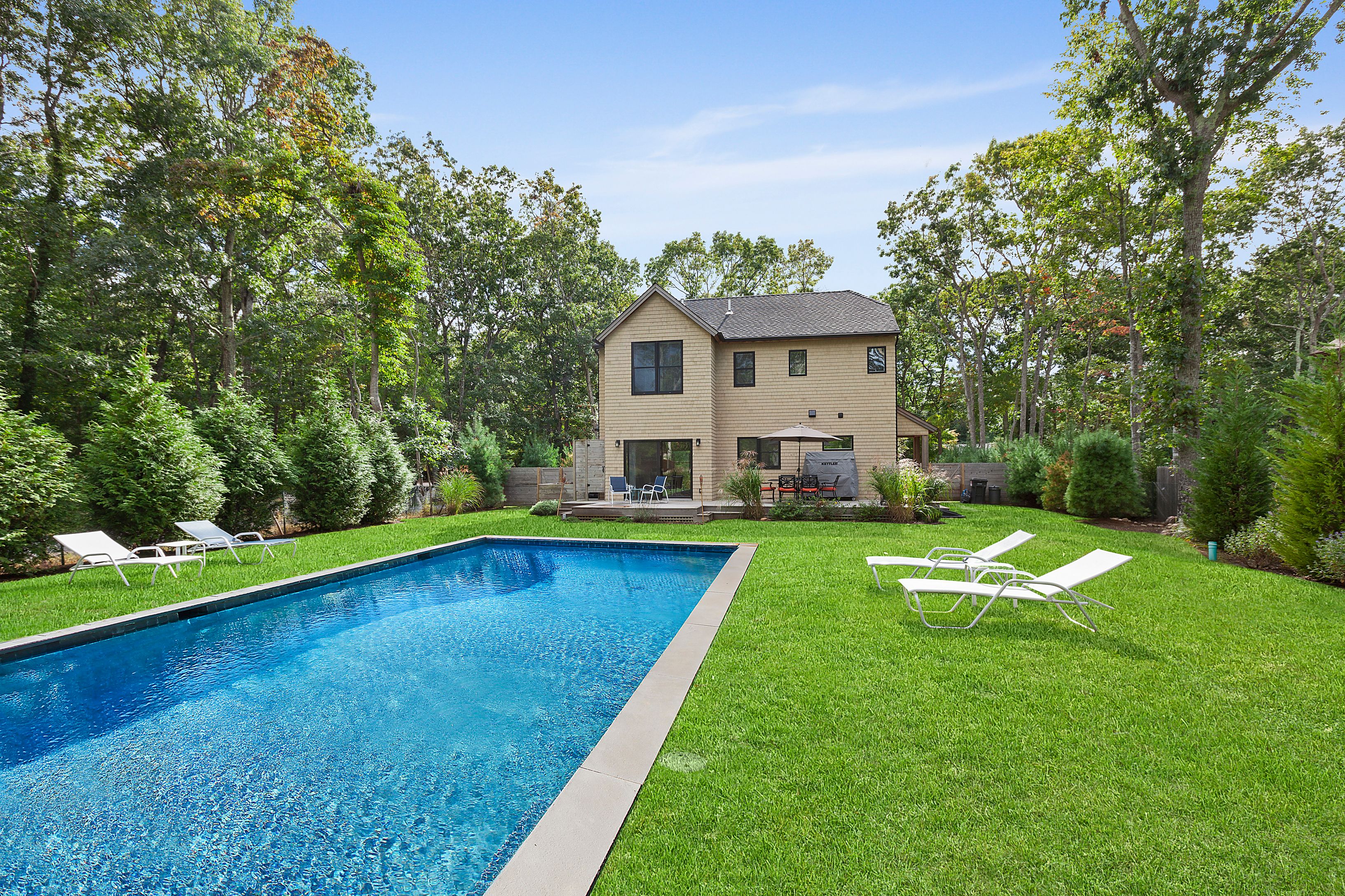 a view of a house with a swimming pool and a yard