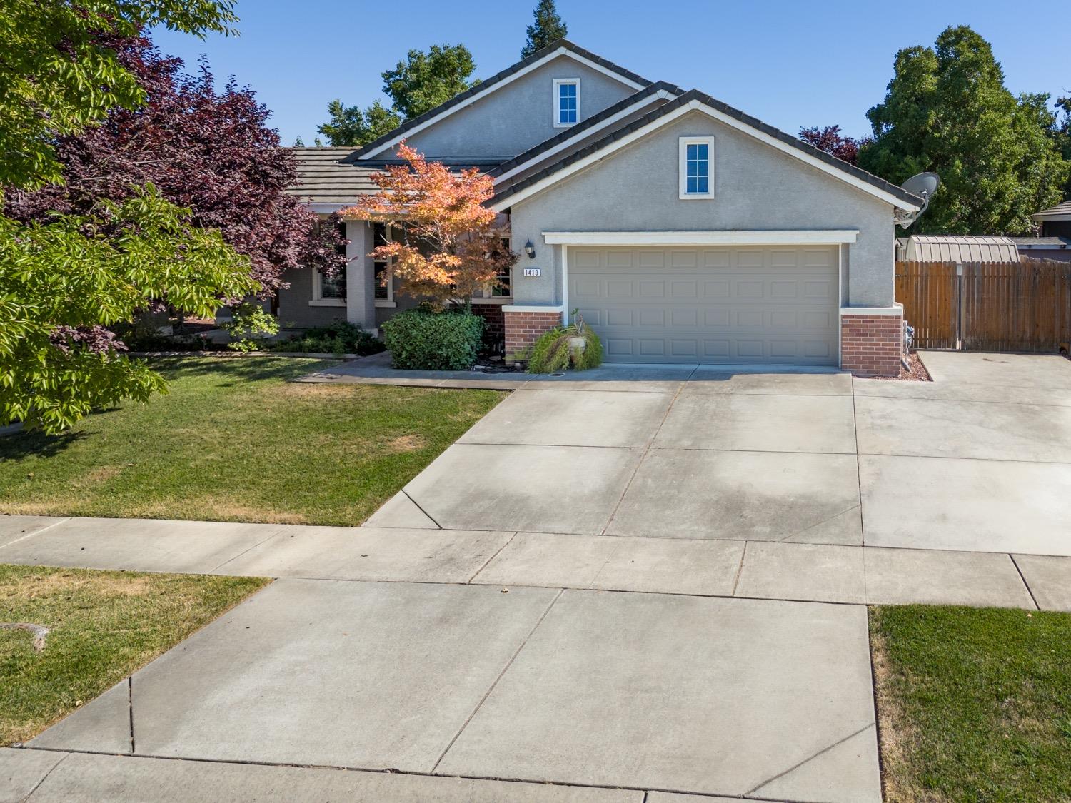 a front view of a house with a yard and trees