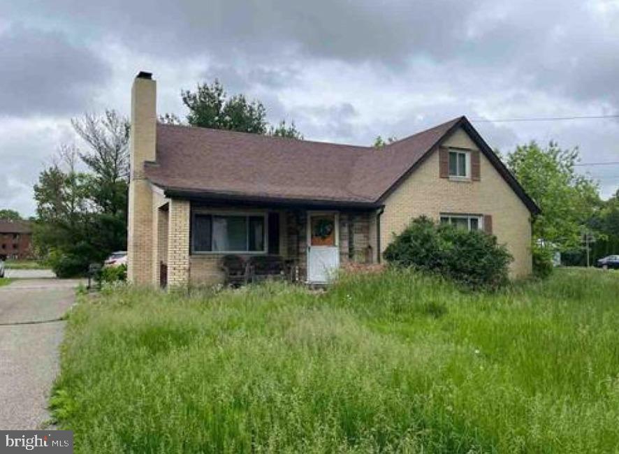 a front view of a house with a yard and trees