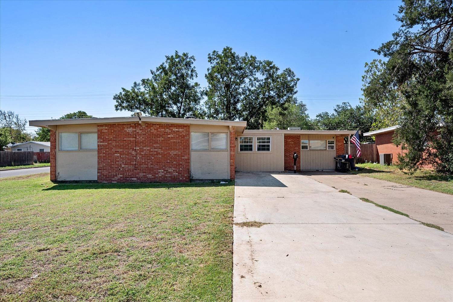 a view of a house with backyard space and tree