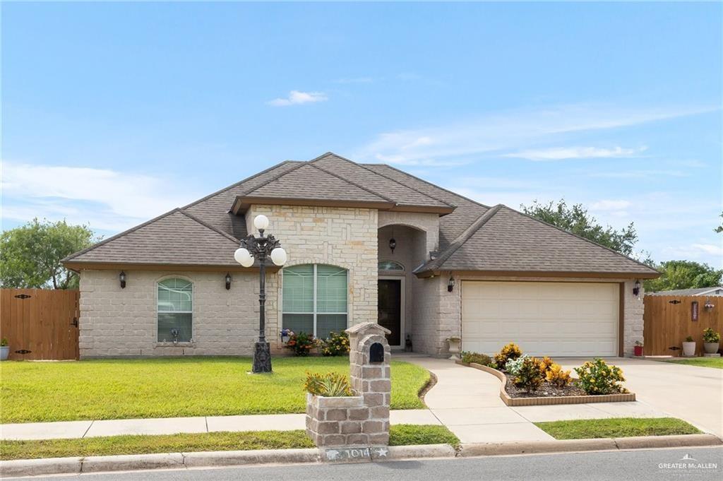 a front view of a house with a garden and yard