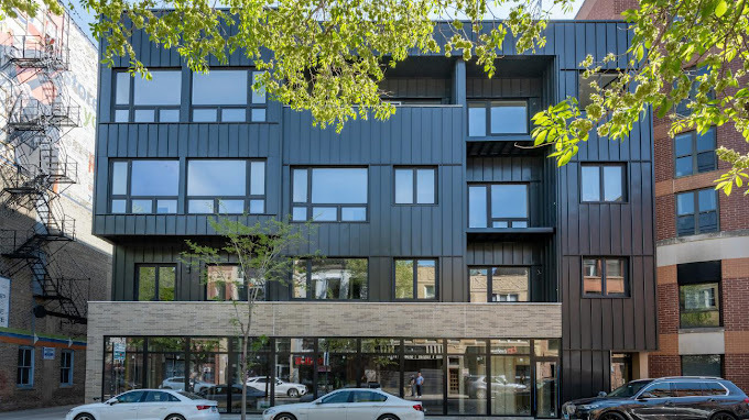 a view of a building with front door and tree