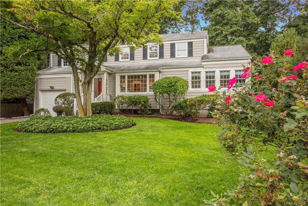 a front view of a house with a garden and yard