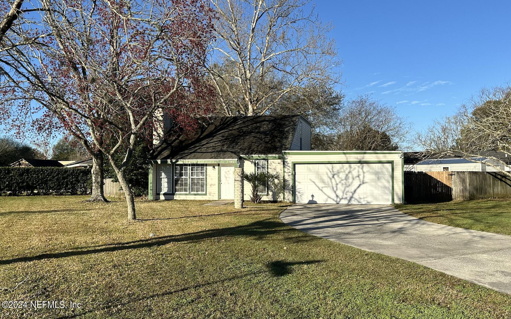 a view of a house with backyard and trees