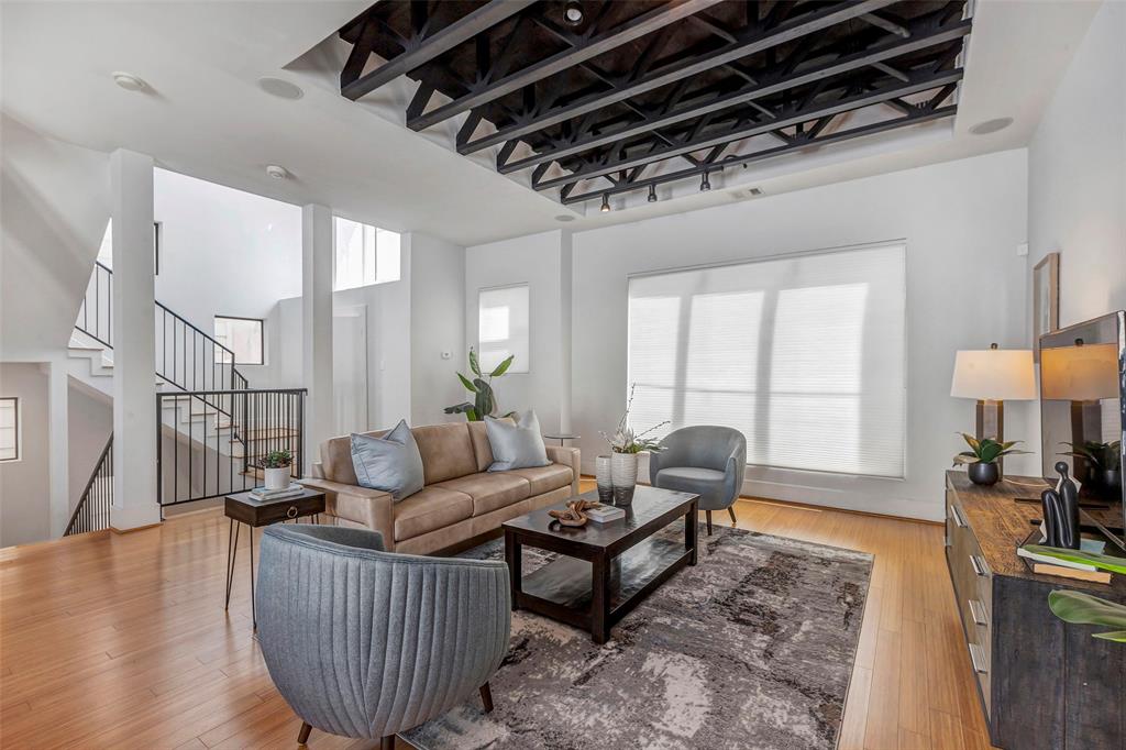 a living room with furniture a wooden floor and a large window