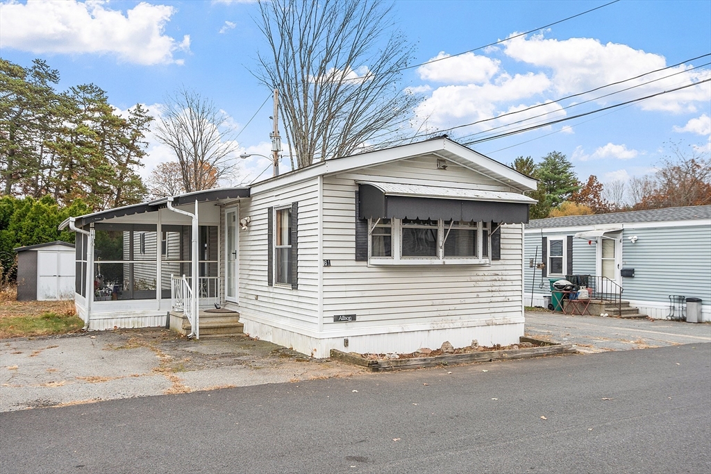 a front view of a house with a road