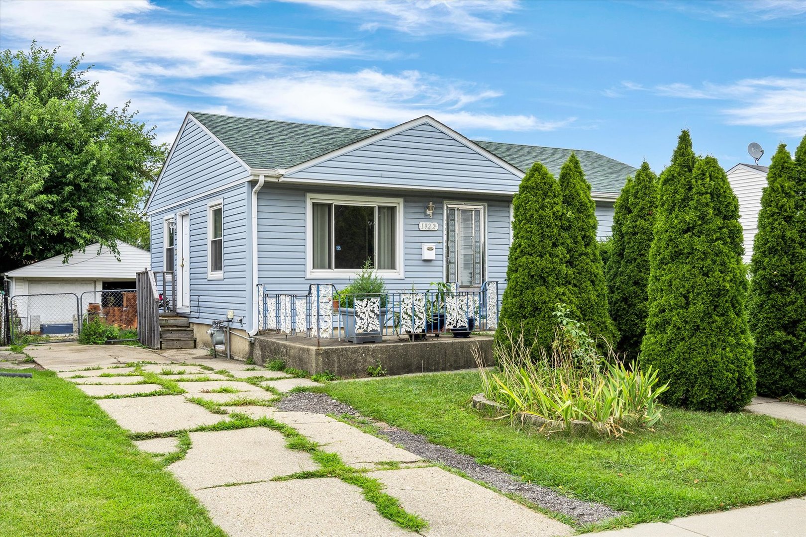 a front view of a house with a yard and potted plants