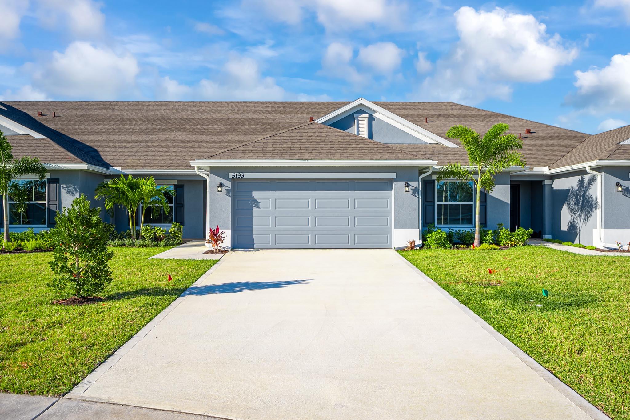 a front view of a house with a yard and potted plants