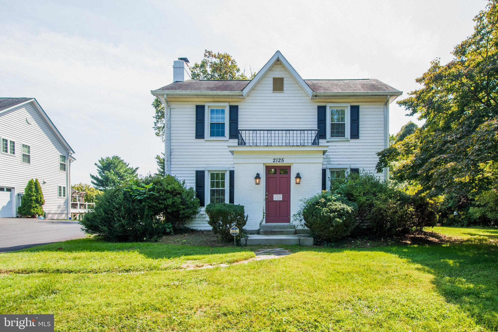 a front view of a house with a yard and trees