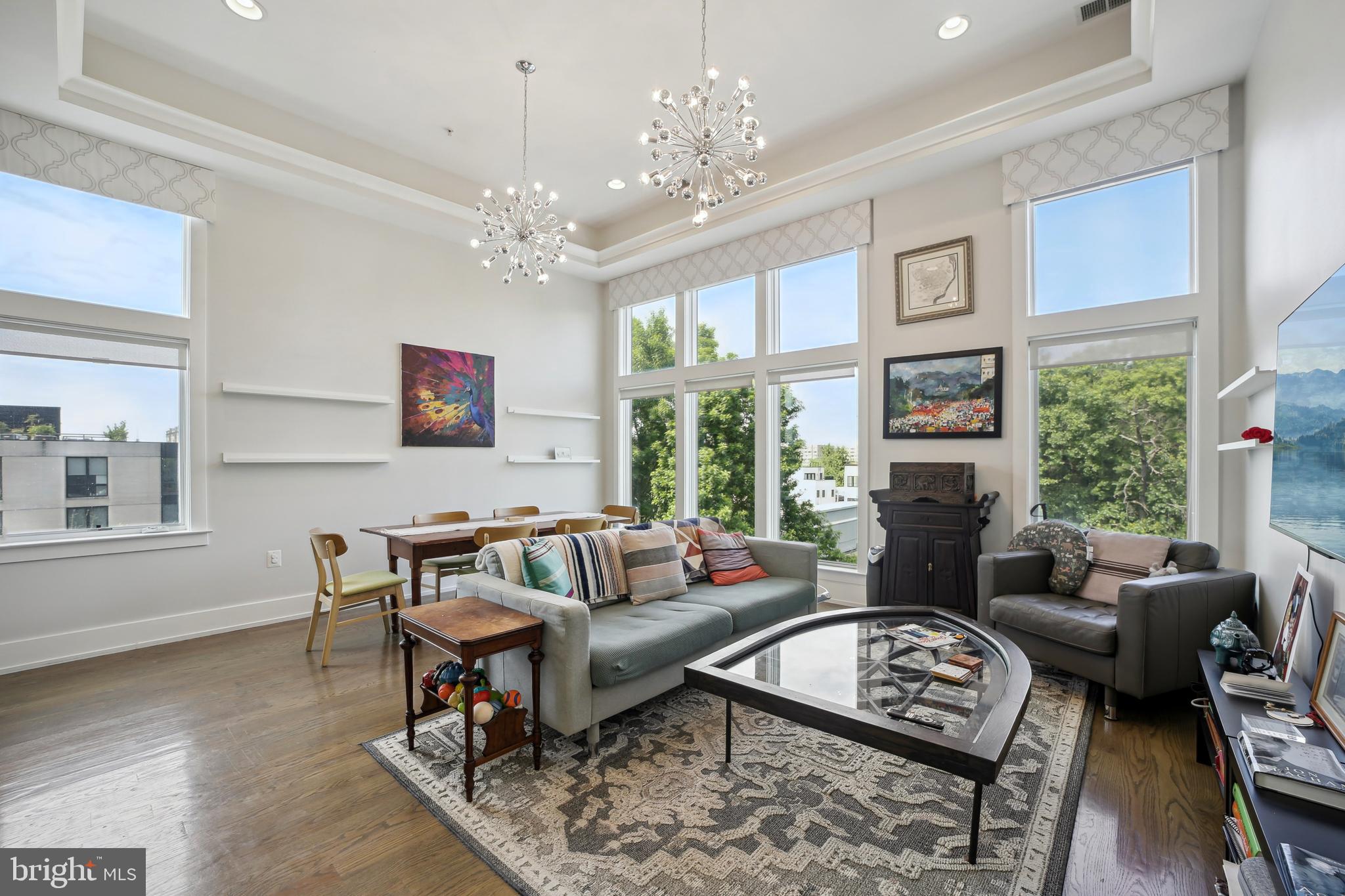 a living room with furniture a chandelier and a table