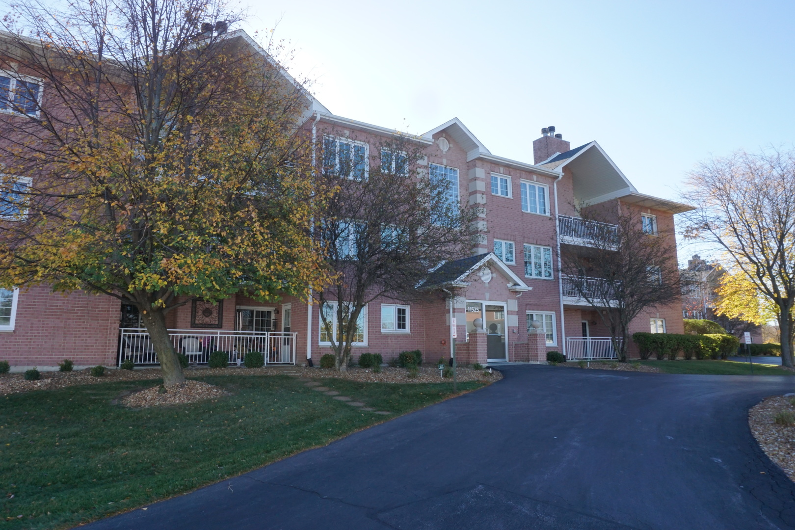 a front view of a house with a garden and tree