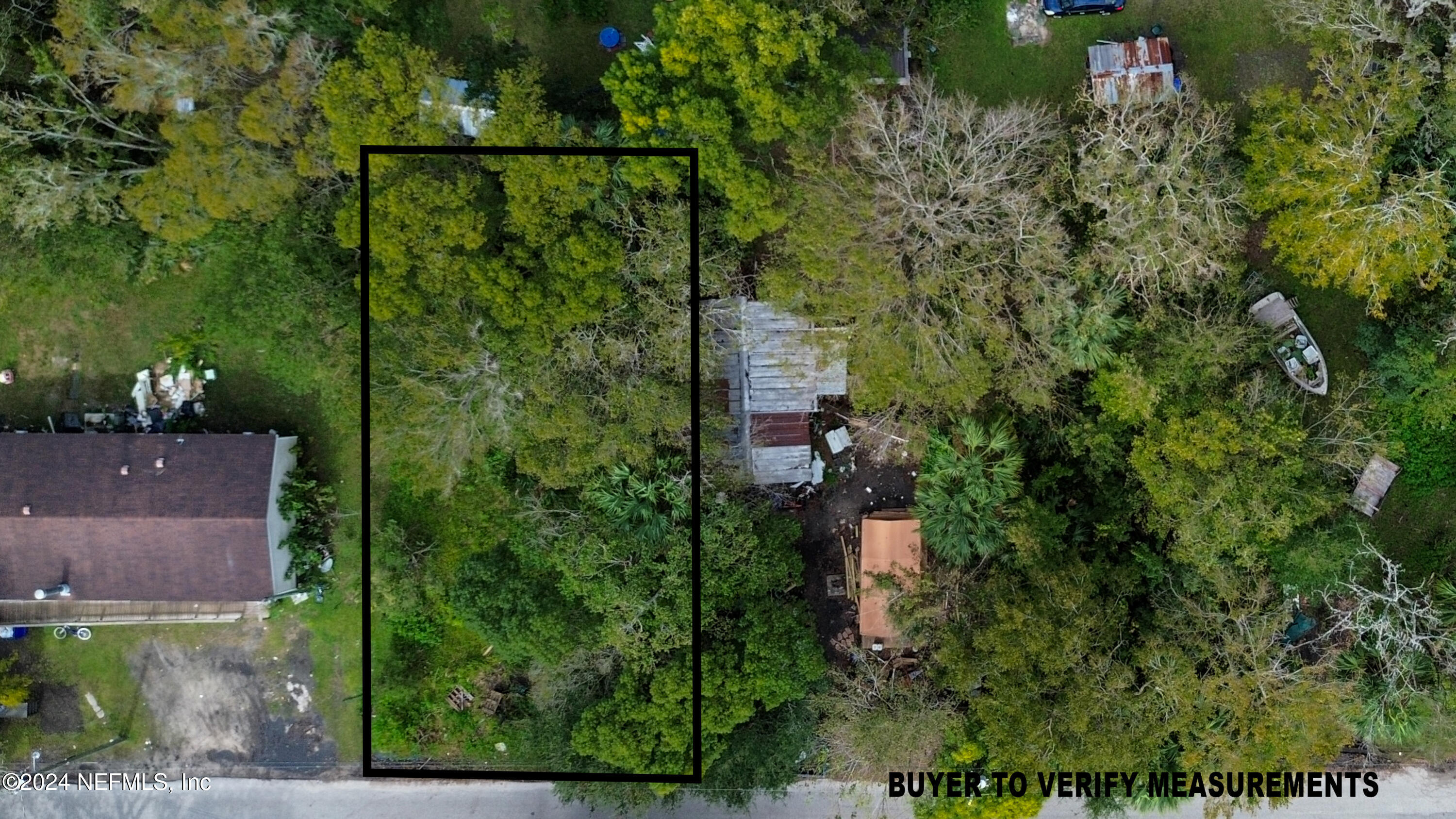 an aerial view of residential house with outdoor space and trees all around