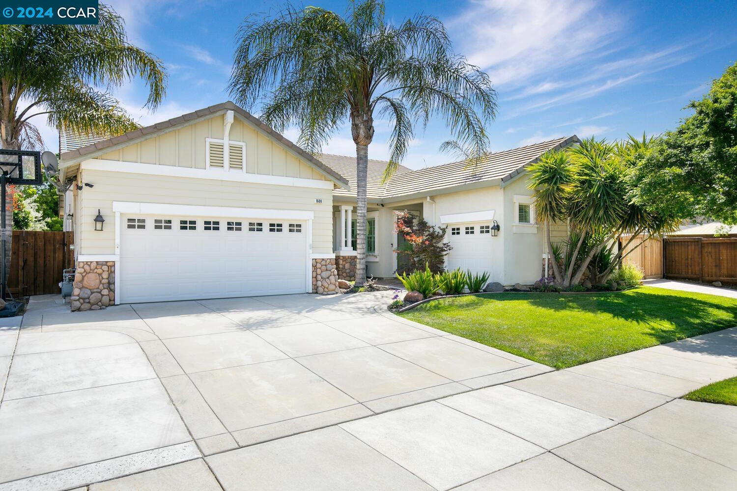 a view of a white house with a yard and palm trees