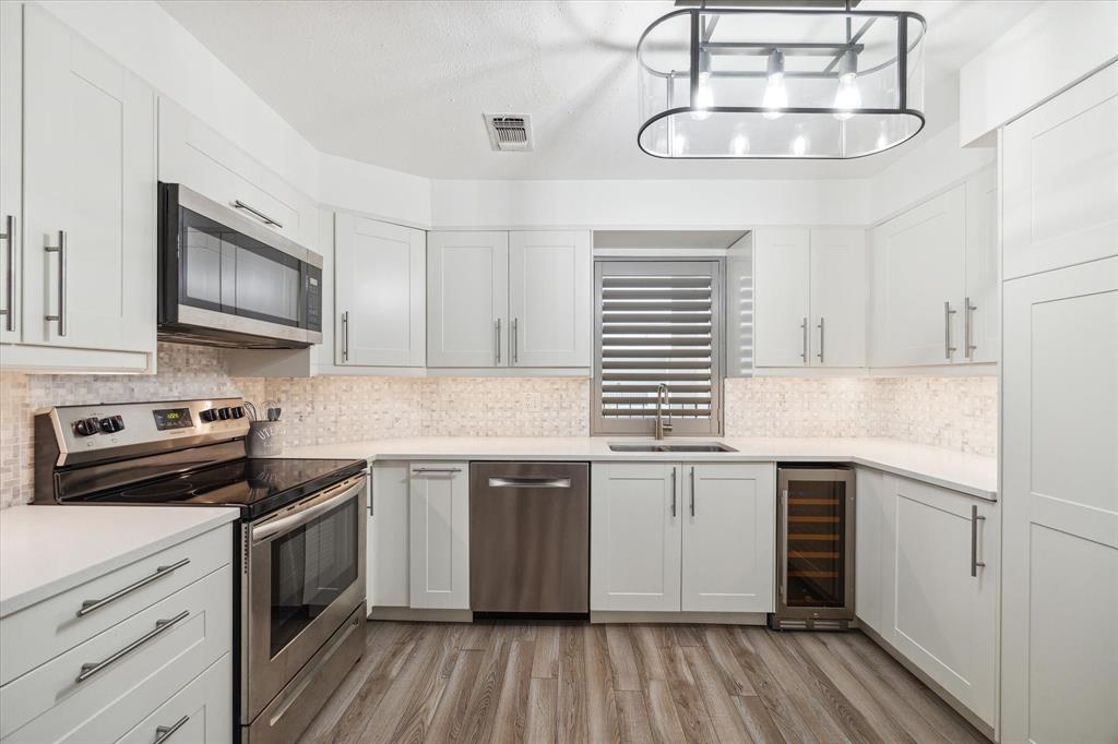 a kitchen with stainless steel appliances granite countertop a sink and stove top oven