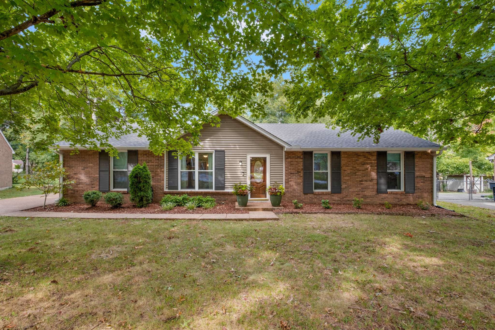 a front view of a house with a yard and trees