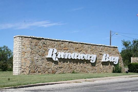 a sign board with buildings in the background