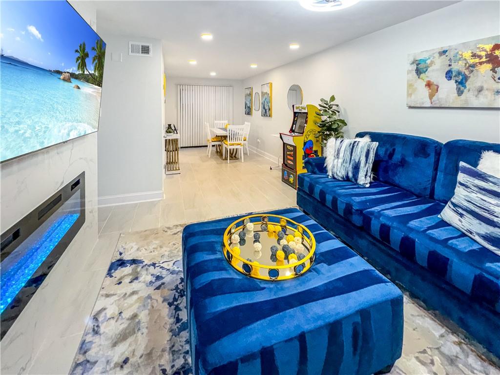 a living room with furniture and a dining table with kitchen view