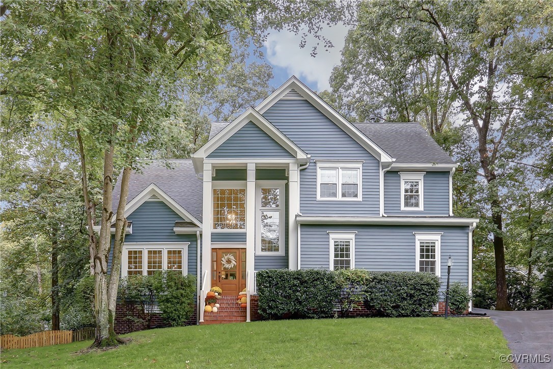 a front view of a house with a yard and trees