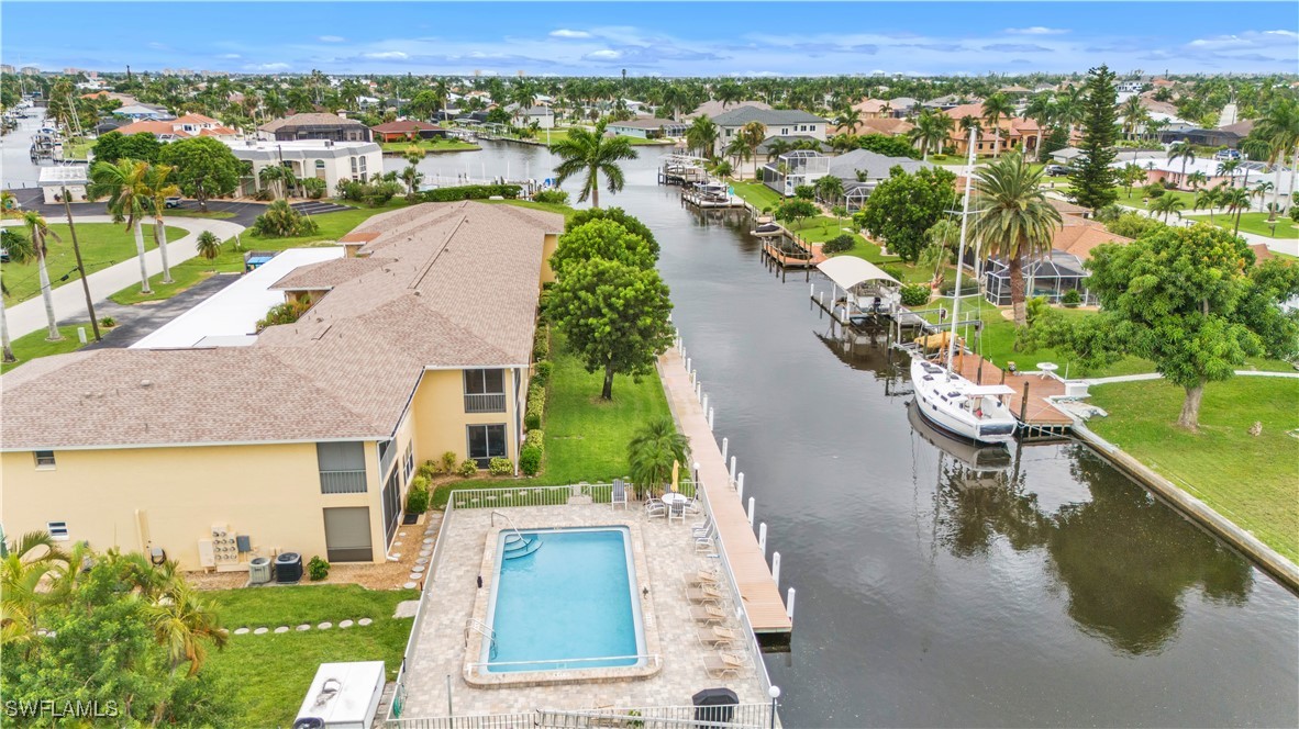 an aerial view of residential houses with outdoor space and swimming pool